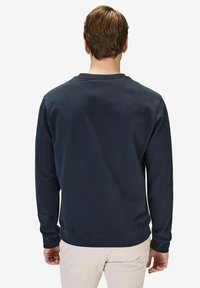 Mörkblå sweatshirt med långa ärmar, rund hals och ribbade muddar. Slät textur och minimalistisk design utan synliga grafiska element eller detaljer.