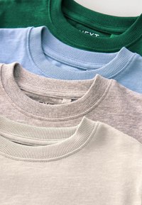 Četri salocīti crew neck sporta krekli sakrauti zaļā, gaiši zilā, bēšā un balta krāsā, parādot riboto apkakles detaļu.