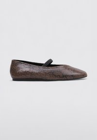 Ballerines en cuir bronzé avec un strap élastique noir sur le coup de pied et une semelle plate et flexible. Texture lisse, design effilé.