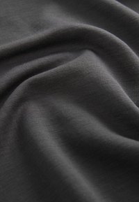 Czarna tkanina o gładkiej fakturze, z subtelnymi, splecionymi wzorami. Materiał wydaje się miękki i lekko drapowany.