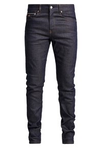 Tummansiniset farkut kapealla istuvuudella, viisi taskua, kontrastisaumaus ja napillinen kiinnitys. Päällä sileä pinta.