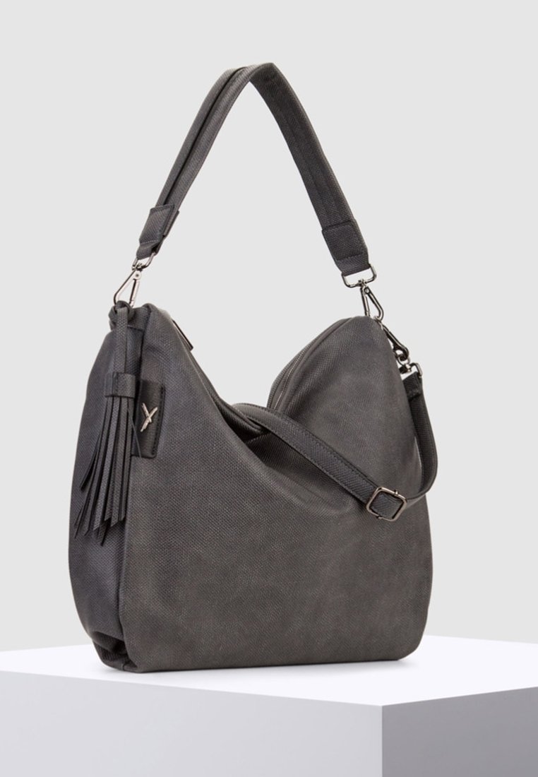 Sac à bandoulière texturé gris foncé avec bandoulière réglable, fermeture éclair et pompon décoratif sur fond neutre.