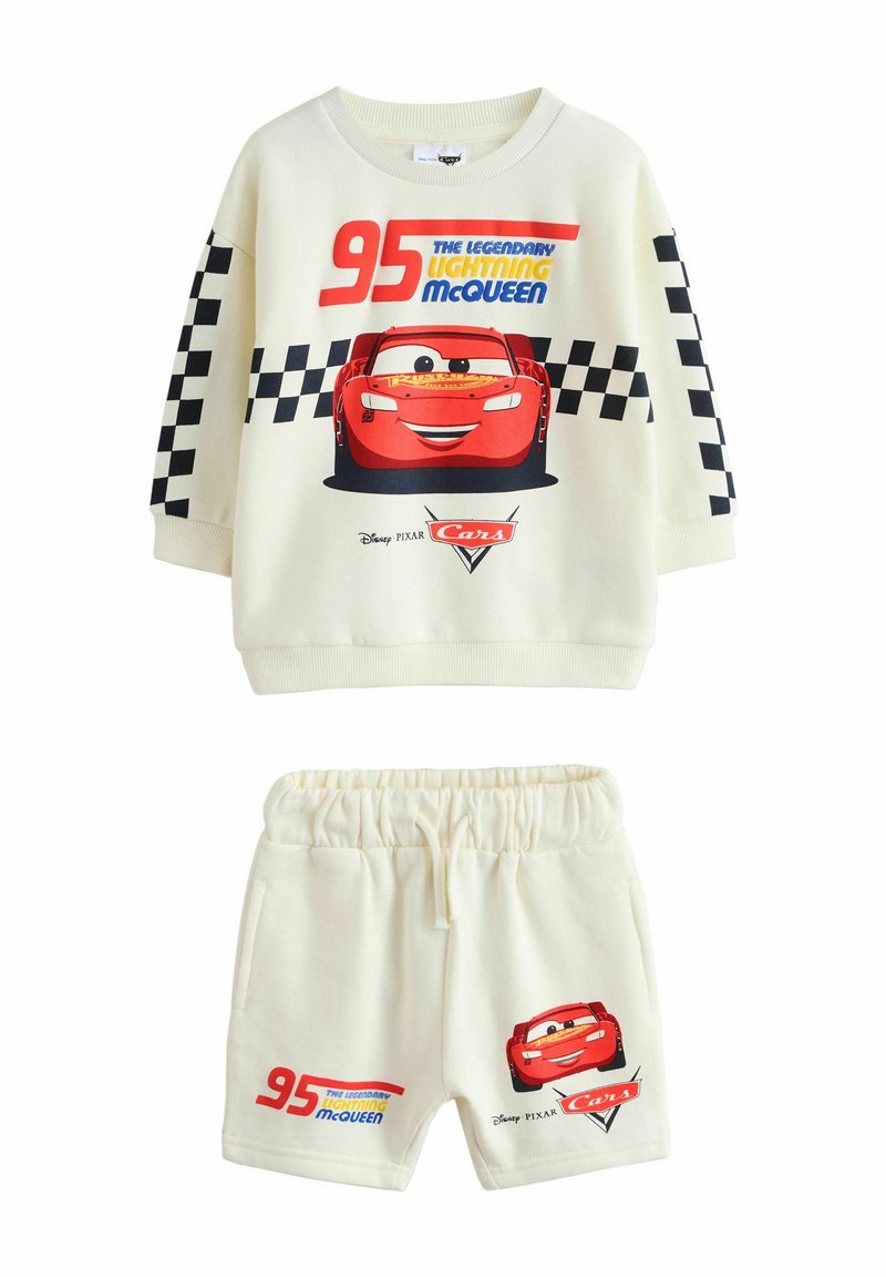 Sudadera blanca con un gráfico de un coche rojo y el texto "95 Lightning McQueen"; pantalones cortos a juego con un diseño similar, cinturilla elástica.