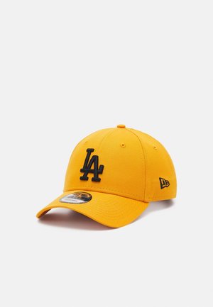 Gul baseballkasket med sort "LA" logo foran og lille sort emblem på siden, vist i en let vinkel på hvid baggrund.