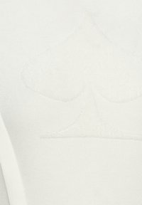 Wit gebreide stof met een subtiele, reliëf spade logo in het midden, met een gladde textuur en zonder extra accenten.