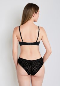 Schwarzer BH und passende Pantys mit einer strukturierten, gemusterten Gestaltung. Der BH verfügt über verstellbare Träger und einen Haken- und Ösenverschluss auf der Rückseite.