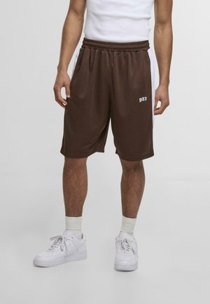 Brown athletic shorts with an elastic waistband and side pockets. Features white "DEF" text on the front. Worn with white sneakers and socks.