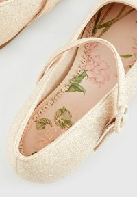 Balletskor i glittrande ljusrosa med rund tå och tunn rem. Innersulan har blommönster i mjuka färger.