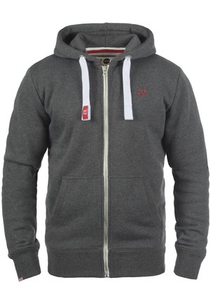 Grijze ritshoodie van zachte stof, met een voorzak, witte trekkoorden en een rood logo op de borst. Soepele textuur.