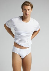 Weißes Baumwoll-T-Shirt mit kurzen Ärmeln und einer weißen Unterhose. Glatte Textur, enganliegendes Design und keine sichtbaren Muster oder Grafiken.
