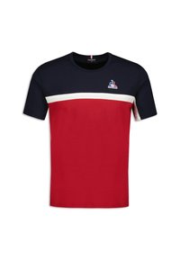 Röd och marinblå t-shirt med kort ärm, prydd med ett vitt horisontellt rand och logotyp på bröstet; tillverkad av bomullstyg med en mjuk textur.