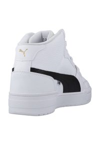 Kohvris kõrged valged tennisetossud tekstureeritud nahkpealisega, musta triibuga ja kuldsete logo aktsentidega, lame tald ja polsterdatud kaelus.