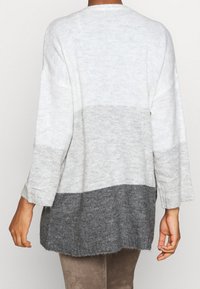 Maglione lavorato a maglia grigio chiaro e grigio scuro con una vestibilità rilassata, maniche a tre quarti e un orlo posteriore più lungo. Tessuto morbido, semplice gradiente di colore.