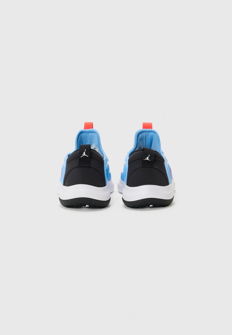 Zapatillas deportivas negras y azules con parte superior de malla y acentos rojos, además de una suela blanca. Marca destacada en el talón y en la pestaña de agarre.