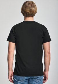 Czarny t-shirt z krótkim rękawem, wykonany z bawełny, o klasycznym kroju, z okrągłym dekoltem i gładkim tyłem.