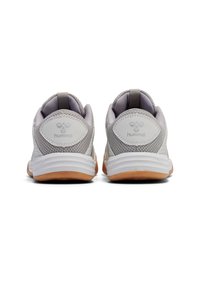 Baskets de sport en maille grise avec semelles blanches, présentant un design texturé et un accent de logo. L'arrière comprend une languette pour un enfilage facile.