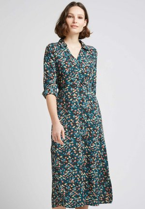 Robe florale avec un col, présentant une base bleu-vert et des motifs multicolores. Manches longues, ceinture à la taille et jupe longueur genou.