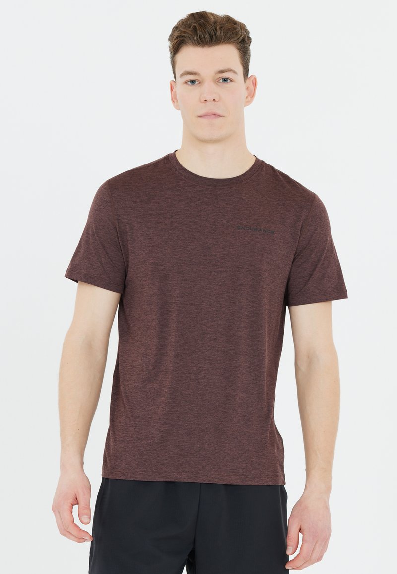 Maroon lyhytnukkainen t-paita teksturoitua kangasta. Ominaisuuksia pyöreä kaula-aukko ja pieni musta logo edessä, yhdistettynä tummiin shortsiiin.