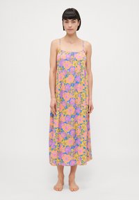 Floral maxi dress in lightweight fabric, featuring pink and yellow flowers on a purple background, with thin adjustable straps and a loose fit.