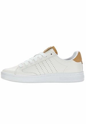 Zapatilla blanca de corte bajo con cordones blancos, rayas laterales perforadas y detalles marrones texturizados en el talón y la lengüeta.