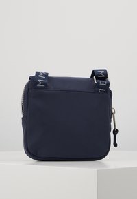 Borsa a tracolla blu navy con superficie in nylon liscia, chiusura a cerniera e doppie maniglie. Forma rettangolare minimalista, senza motivi visibili.