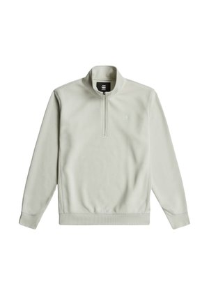 Sweat-shirt gris clair zippé avec un col haut, des poignets et un ourlet côtelés, présentant un petit logo sur la poitrine et une texture douce et lisse.
