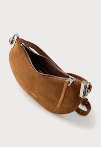 Borsa a mano in camoscio marrone con forma arrotondata, chiusura con cerniera argentata e tracolla removibile. Interno foderato in tessuto scuro.