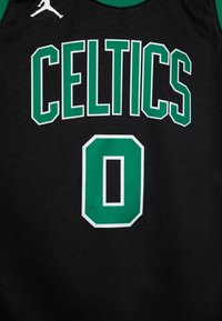Camiseta de baloncesto negra con "CELTICS" en letras gruesas verdes y el número "0" debajo, con contornos blancos y un cuello verde.