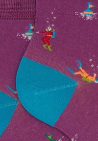 Calzini con una base viola che presentano sub e scene subacquee in colori vivaci. Cuffia blu chiaro, punta rinforzata e sezioni del tallone.