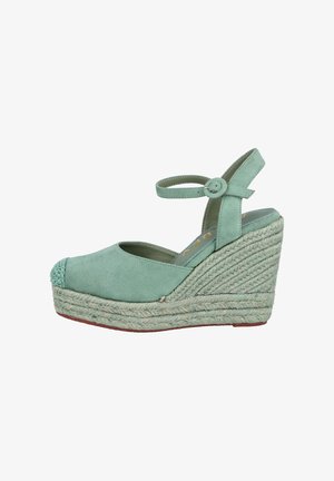 Espadrille de cuña en verde menta con parte superior de ante, tirante elástico en el tobillo y plataforma de yute trenzado. Punta redondeada con detalles texturizados en la parte delantera.
