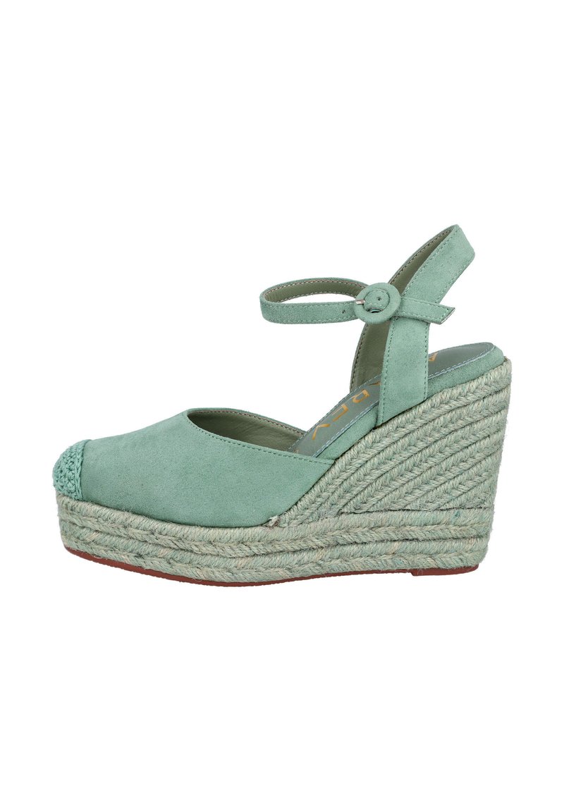 Espadrille de cuña en verde menta con parte superior de ante, tirante elástico en el tobillo y plataforma de yute trenzado. Punta redondeada con detalles texturizados en la parte delantera.
