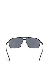 Svarta rektangulära solglasögon med grå linser, tunt metallram och justerbara nässtöd. Smala armar sträcker sig bakåt från linserna.