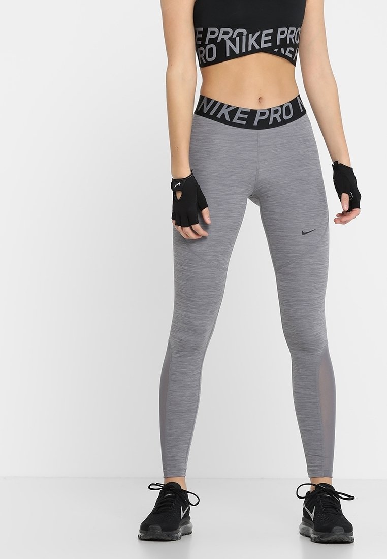 Leggings sportivi grigi con un design aderente, dotati di una vita con marchio nera e inserti in rete lungo i lati. Completati da guanti neri.