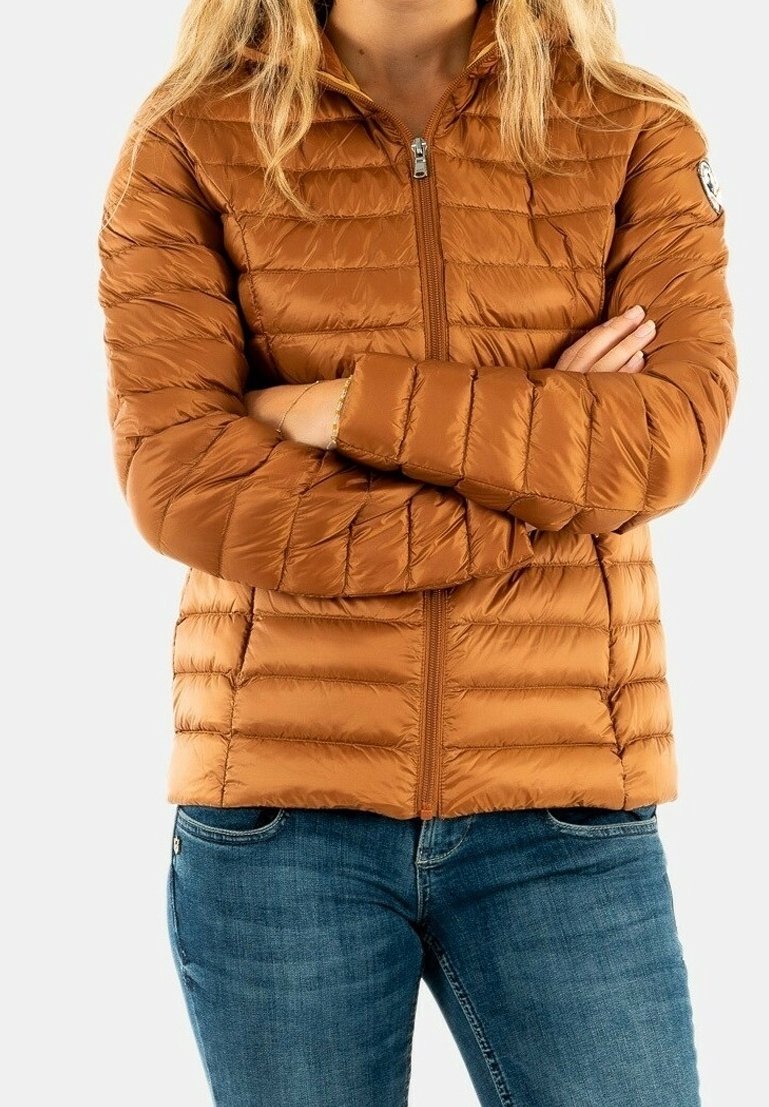 Veste matelassée marron avec couture horizontale, fermeture éclair à l'avant, col montant et poignets élastiques, associée à un jean bleu.