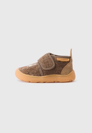 Braunes Kleinkinderschuh mit orangefarbener Gummisohle, Klettverschluss, weichem Filzobermaterial und Wildlederfersenlasche auf weißem Hintergrund.