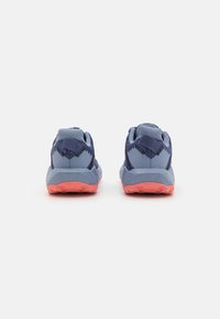 Chaussures de sport bleu marine et bleu clair avec une tige texturée, un col rembourré et une semelle en caoutchouc à motif rose.