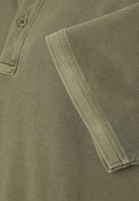 Polo w kolorze oliwkowym z teksturowanej tkaniny, z kołnierzykiem zapinanym na dwa guziki oraz starannie przeszytymi rękawami dla schludnego wykończenia.