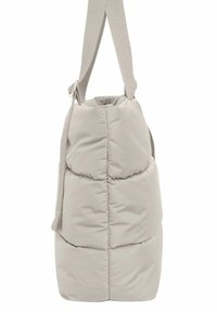 Dikke beige tote bag met een gestructureerde vorm, verstelbare stoffen schouderband en een zachte, gladde textuur. Heeft gestikte delen voor extra detail.