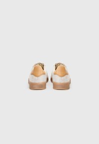 Sneaker beige con tomaia in lana testurizzata, dettagli in pelle testa di moro sul tallone e suola in gomma, viste da dietro.