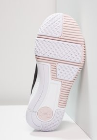 Black athletic shoe with a textured rubber sole featuring a white and pink outsole. Logo located on the heel.