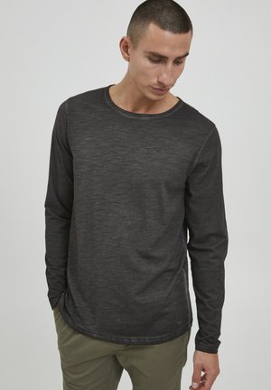 Long-sleeve black shirt with a round neckline, made of textured fabric. Features a subtle heather pattern and visible stitching accents.