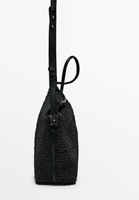Borsa intrecciata nera con una superficie texturizzata, caratterizzata da accenti in pelle, una tracolla regolabile e una forma conica.