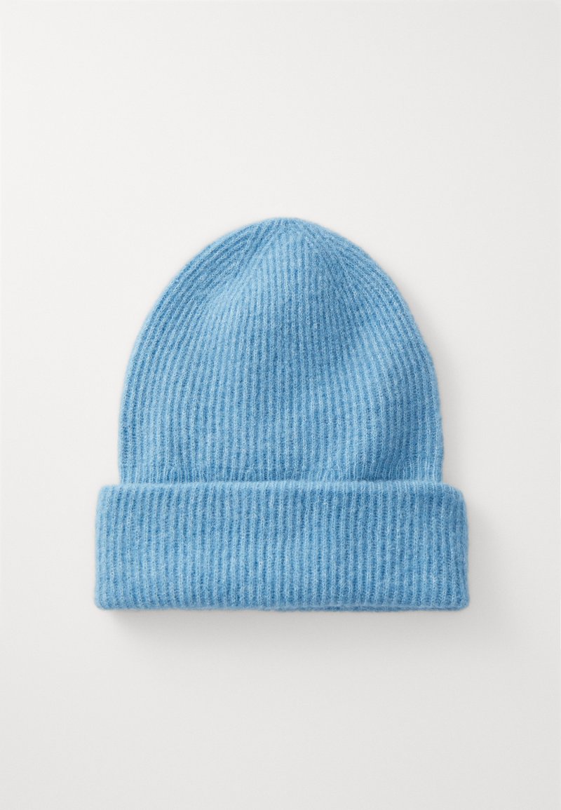 Căciulă tricotată ribbed de culoare bleu deschis, cu tiv rulat. Fabricată dintr-o textură moale, are dungi verticale și o vârf rotunjit.
