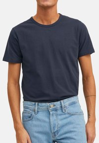 Donker marineblauw T-shirt met korte mouwen en een ronde hals in katoen, met een relaxte pasvorm, gecombineerd met lichtblauwe denim jeans.