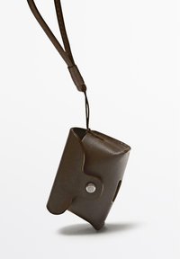 Pochette in pelle marrone con chiusura a bottone a pressione, attaccata da una sottile tracolla, caratterizzata da una superficie liscia e bordi arrotondati.
