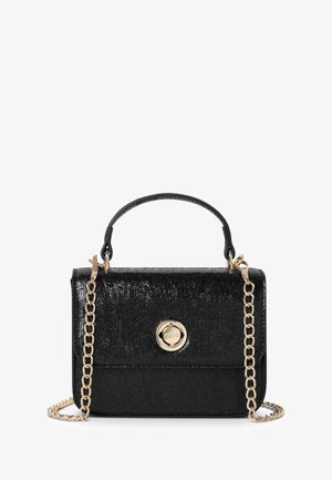 Schwarze, strukturierte Handtasche mit einem goldfarbenen, runden Verschluss, einem Griff oben und einem abnehmbaren Kettenriemen. Kompaktes Design mit glatter Oberfläche.