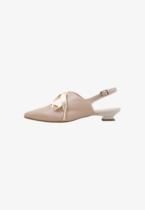 Zapato slingback beige de cuero con punta afilada, tacón bajo tipo kitten, correa con hebilla y cordón decorativo de cinta de satén en la parte superior.