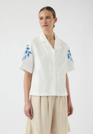 Vit kortärmad skjorta med blå broderad blomdesign på axlarna, med knäppning framtill och avslappnad passform.