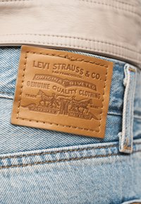 Ανοιχτό μπλε τζιν παντελόνι με δερμάτινο λογότυπο Levi Strauss & Co. σε καφέ απόχρωση ραμμένο πάνω από την πίσω τσέπη.