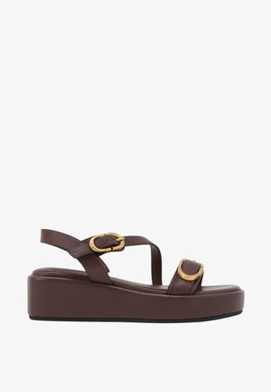 Brown leather platform sandal with two gold buckles and a slingback strap on a white background.